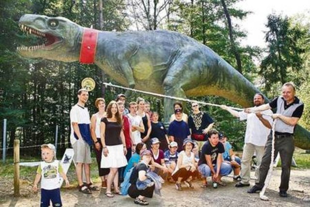 Die Klienten der Caritas-Werkstätte "zähmten" mit ihrem Leiter Peter Rotheneder und Styrassic Park-Chef Markus Ulrich den Dinosaurier.         Foto: WOCHE