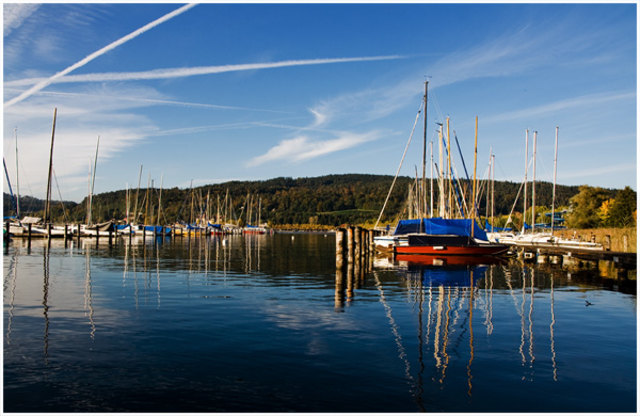 Segelboot spiegeln sich im Wasser des Wörthersee's