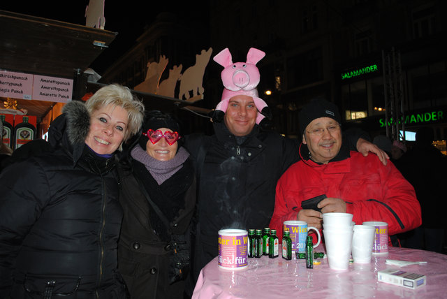 Fröhliche Freundesrunde genießt ein paar Gläser Punsch mit "Extrainhalt".