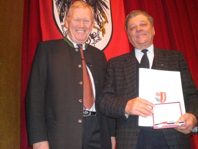 Bgm.Ing. Wolfgang Holub überreicht Alfons Hofreiter das Ehrenzeichen der Marktgemeinde Jenbach in Gold. Foto: Lorenzetti