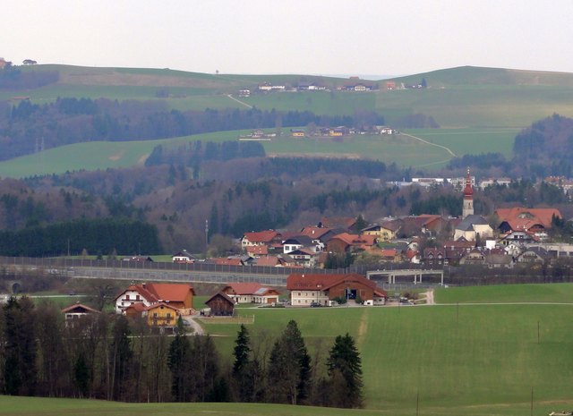 Ansicht vom Am Höhenrain aus: der Weiler Haubenöd und Hallwang, dazwischen führt die Autobahn hindurch. Im Hintergrund befindet sich der Voggenberg, Gemeinde Bergheim und teilweise Elixhausen