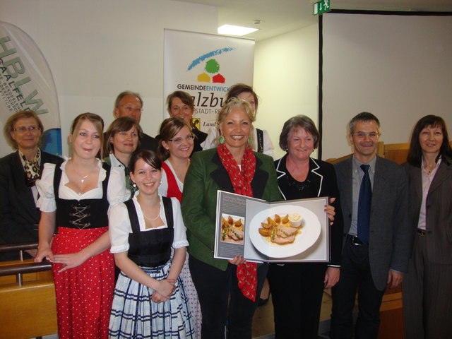 Ehrengast LR Tina Widmann nimmt von Direktorin Ingrid Mittendorfer einen Bildband, der Spezialitäten aus dem Pinzgau und Italien vorstellt, entgegen. Ganz rechts die Salzburger Projektleiterin des EU-Projektes, DI Christine Stadler.        Foto: Kalss