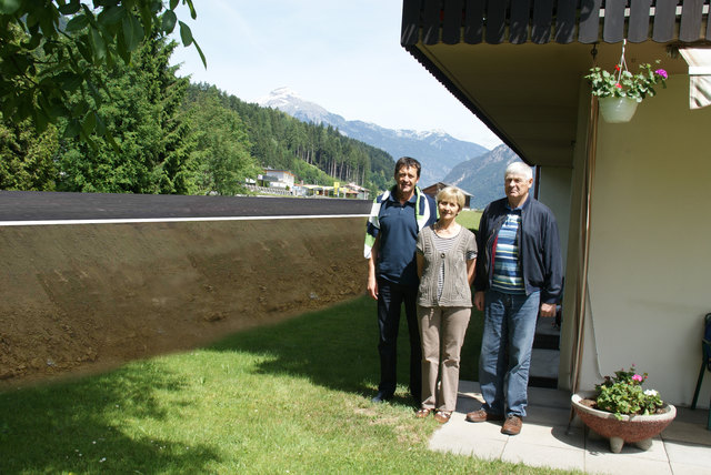 Unter dem Balkon, rund sechs Meter von der Hausmauer entfernt, würde die Parallelstraße beim Haus von Familie Zeller verlaufen. Im Bild: Manfred Zeller (l.) am Elternhaus mit Vater Hermann und Mutter Berta. | Foto: Bildmontage Altenburger