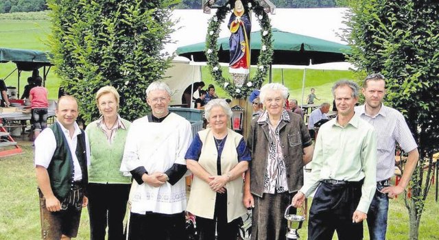 LAbg. Anton Gangl, Anni Schmeer, Pater Gustav, Elisabeth Gollenz-Maier, Johanna Leopold, Franz Ulrich und Obmann Fredi Leopold bei der Kreuzsegnung.