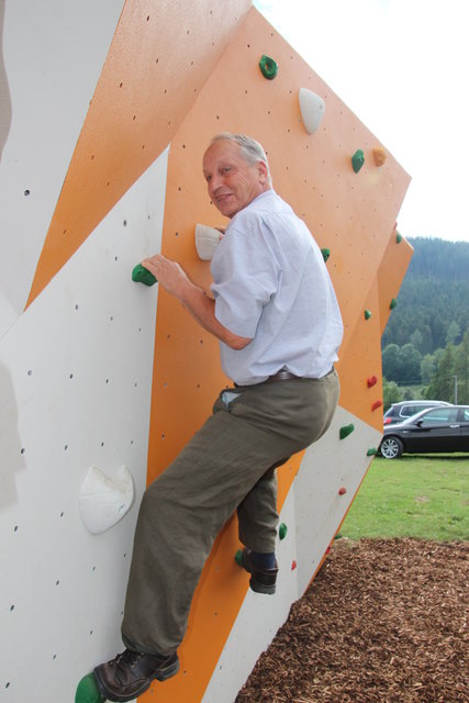 Obmann Harald Regenfelder testet die neue Boulderwand beim Sportzentrum in Überfeld