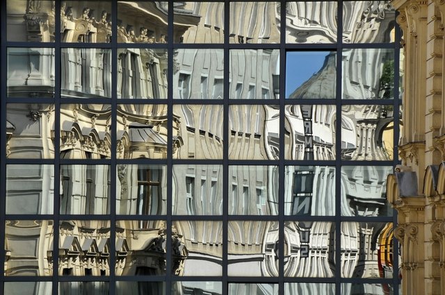 Spiegelung eines alten Hauses in einer modernen Fassade