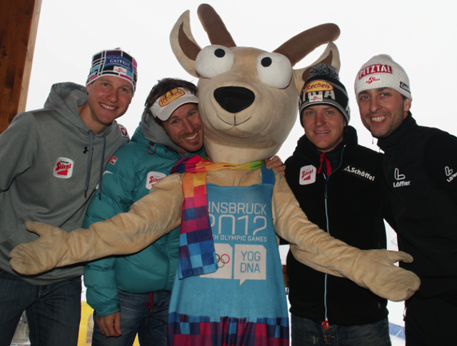 Die Olympischen Team-Goldenen Kombinierer Gruber/Bieler/Kreiner/Stecher mit dem Olympia-Maskottchen Yoggl.