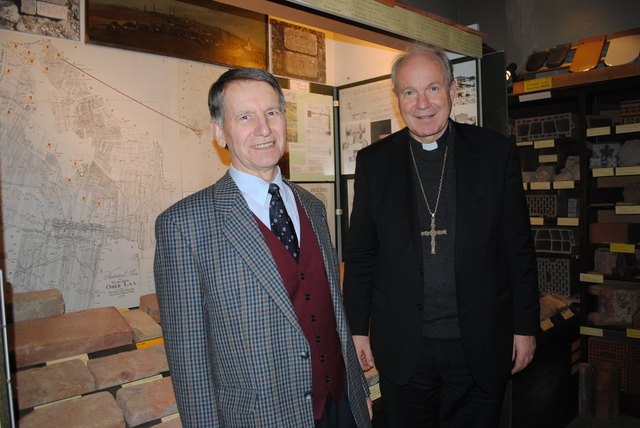 Bezirksmuseums-Mitarbeiter Peter Singer erklärt Kardinal Christoph Schönborn die spezifischen Signaturen, die auf den ausgestellten alten Ziegelsteinen zu sehen sind.