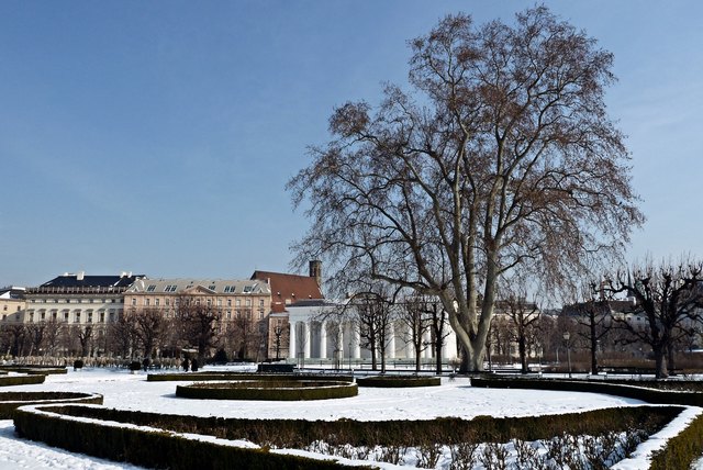 Ein kleines Stadtpanorama mit Minoritenkirche, und dem Theseustempel, bewacht von einer Riesenplatane, die seit über 50 Jahren als Naturdenkmal unter Schutz steht