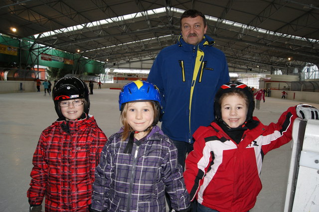 Günter Großauer, Leiter des Steyrer Eislaufplatzes, mit jungen, behelmten Eislauffans. „Ein Helm ist empfehlenswert auf dem Eis, er verringert die Verletzungsgefahr“, sagt Großauer. Foto: Thöne