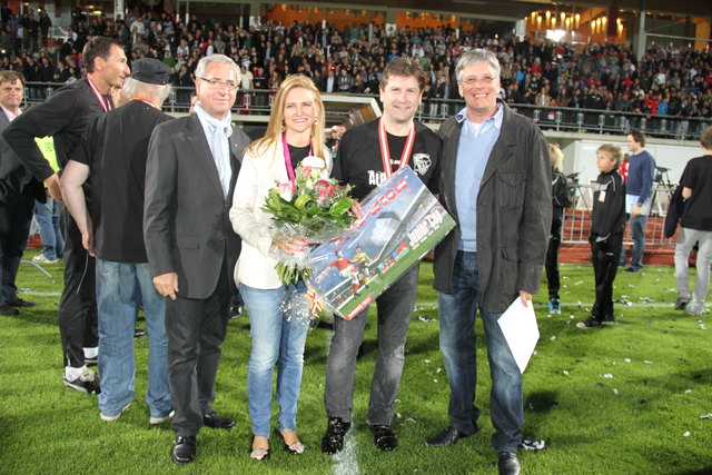 Bgm. Hans-Peter Schlagholz und LHStv. Peter Kaiser gratulierten Präsident Dietmar Riegler und seiner Gattin Waltraud zum Aufstieg mit Blumen und einem Tipp-Kick-Spiel, damit die Taktik für die Bundesliga-Saison bereits während der Sommerpause abseits des Rasens geplant werden kann.