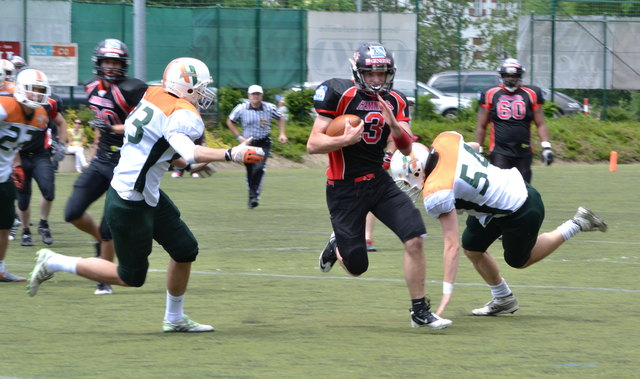 Quarterback Lukas Hütter (#3) weicht bei einem Run der Hurricanes-Defense aus.