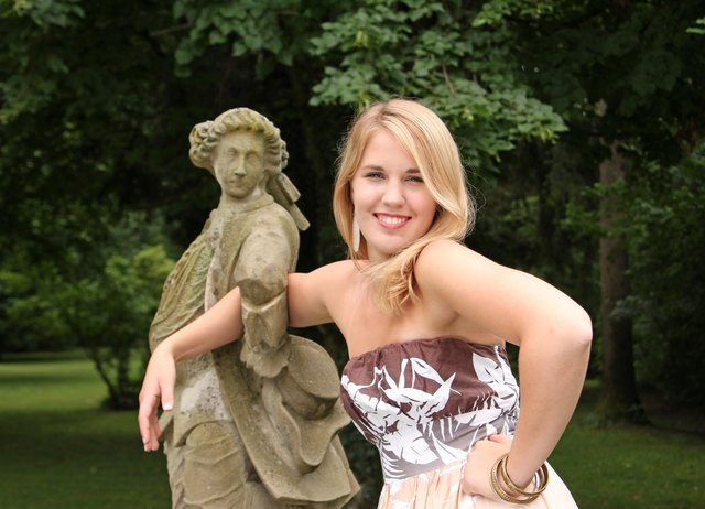 Die fröhliche Lebendigkeit von Isabella im Dialog mit dem Herrn aus Stein. Festgehalten in einer Regenpause im Park von Schloss Leopoldskron in Salzburg: