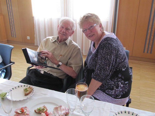 Karl Fröschl-Gresslehner schwelgt mit den Fotos in Erinnerung, neben ihm Maria Scheuwimmer vom Roten Kreuz, die sich auch sehr gefällig um die musikalische Umrahmung kümmerte. | Foto: Rotes Kreuz