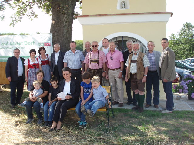 Die tüchtigen Mitarbeiter und die Ehrengäste bei der Segnung des renovierten Bildstockes mit Pfarrer Dr. Joachim Zitko (hinten Mitte), Bürgermeister Andreas Pichler (rechts) und Jutta Schönbauer (sitzend Mitte).