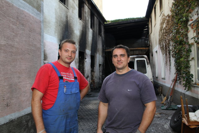 Schwerarbeit: Zeljko und Zoltan transportieren täglich Tonnen an verbranntem Schutt aus dem Haus in der Heinestraße 12.