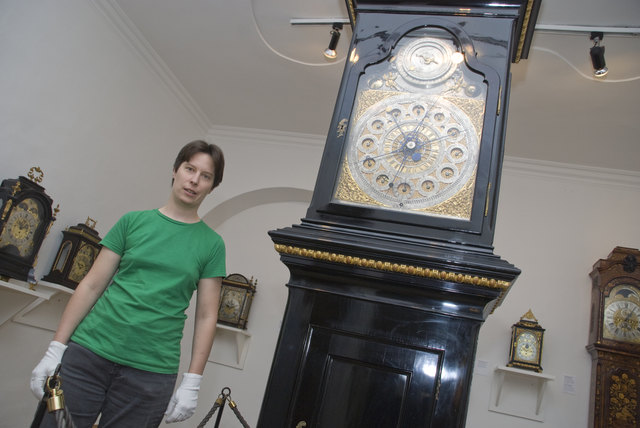 Restauratorin Maria Goiser neben der astronomischen Bodenstanduhr mit 150 Rädchen.