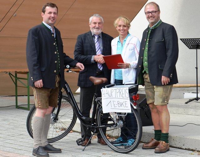 Bgm. Hermann Stockinger (r.), Vizebgm. Evelyn Schobesberger und Obmann Jürgen Lachinger (l.) überreichen das E-Bike an Alois Rager.