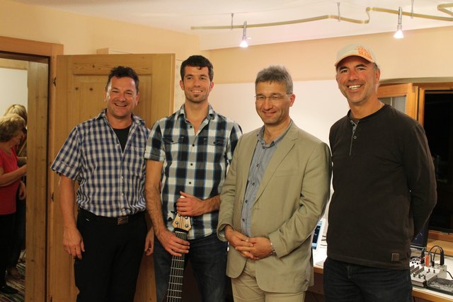 Bernhard Lackner im Bild mit dem Haller Instrumentenbauer Hermann Erlacher – hemage, der seinen 6-saitigen Bass gebaut hat, Vermieter Wolfgang Hörl und Vizebgm. Dietmar Wallner. Foto: tti-Marketing Jenbach
