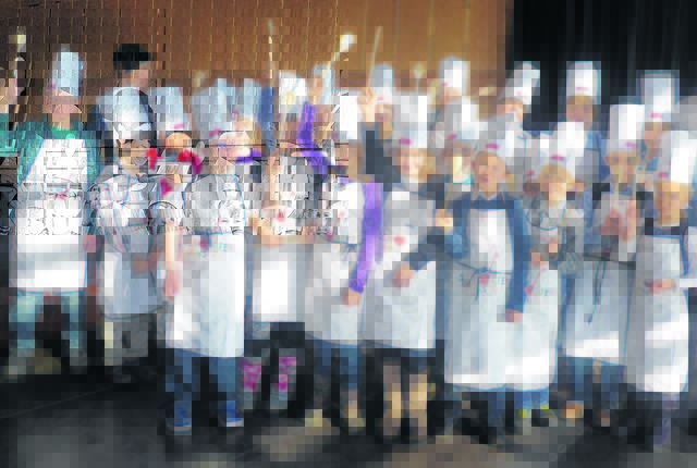 Die Kinder unternehmen in der Kochschule die ersten Versuche beim Zubereiten von Essen