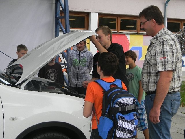 Udo boandl lässt die interessierten Schüler unter die Motorhaube eines neuen E-Cars schauen.