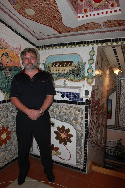 Johann Kreizinger in seinem Haus umgeben von seinen Mosaiken.
