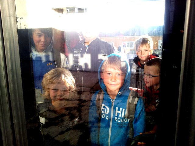 Die Kinder kleben im überfüllten Bus förmlich an der Scheibe der Eingangstür.