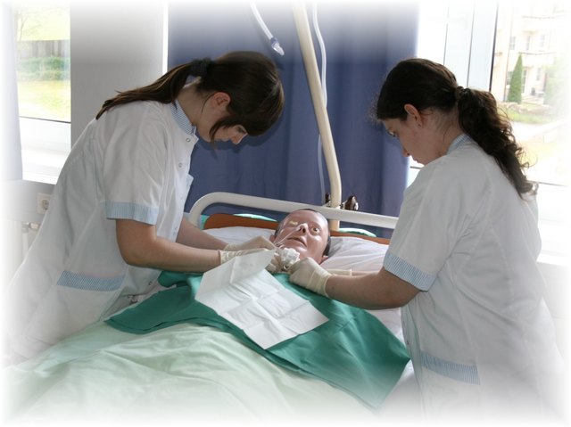 Zwei Schülerinnen der Gesundheits- und Krankenpflege üben an einer Puppe.