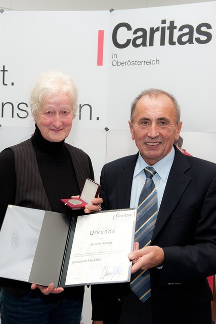 Caritas-Direktor Mathias Mühlberger überreicht Juliane Schild die Elisabethmedaille. | Foto: www.ooe-bezirksblicke.at