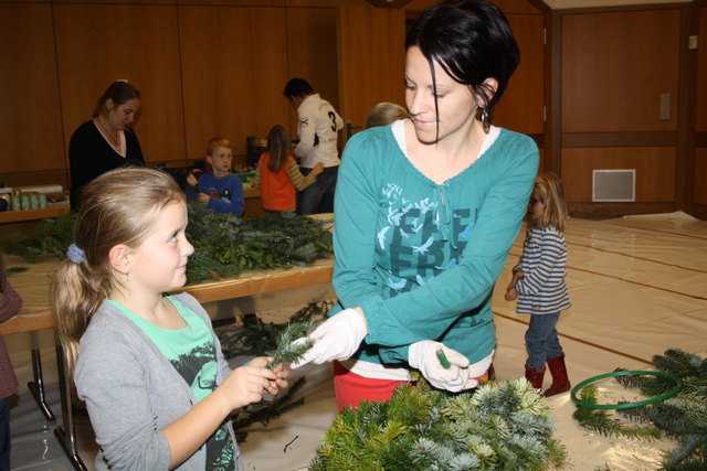 Mama Nicole Magg bindet den Adventkranz, Janine (7) sucht die Schleifen aus. | Foto: EE