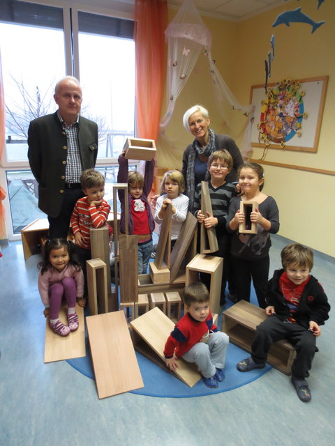 Dir. Ing. Hans Bartl und Kindergartenleiterin Maria Haider freuen sich mit den Kindern über die gelungene Überraschung.