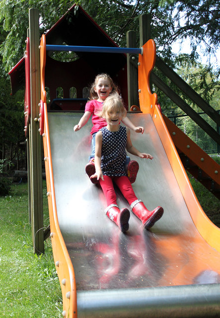Glückliche Kinder beim Lachen und Spielen im wunderbaren Garten.