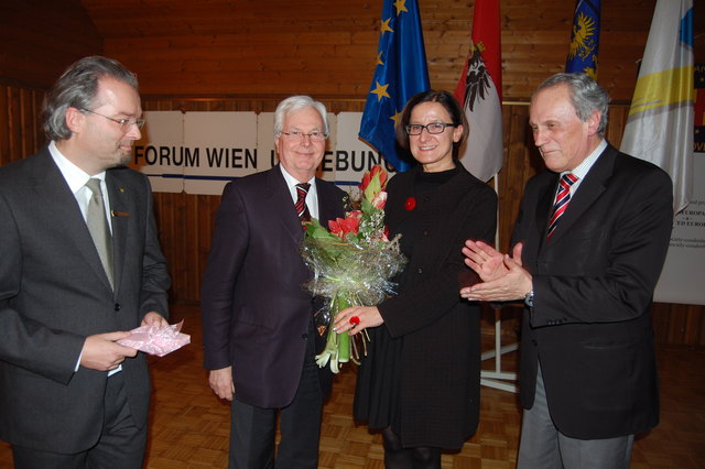 Rainer Krebs überreicht den Blumenstrauß an Innenministerin Johanna Mikl-Leitner, Josef Höchtl klatscht Beifall dazu. | Foto: Zippel