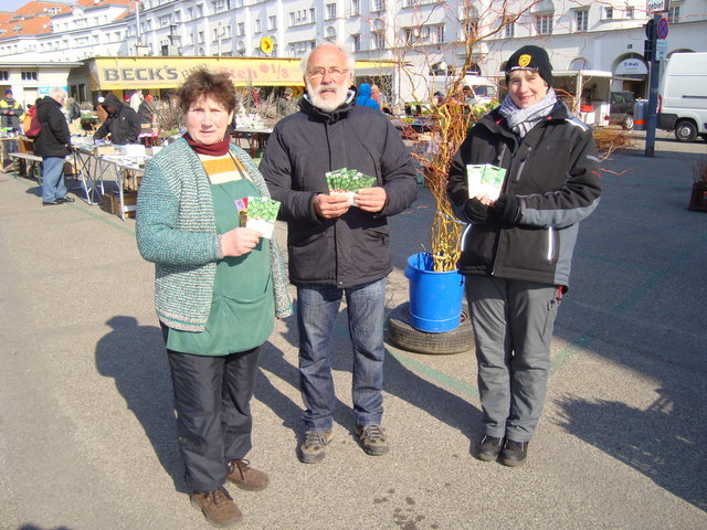 Günter Faulwetter übergibt Samenpäckchen mit Grünkohlgemüse an Anna und Elisabeth Hofer.