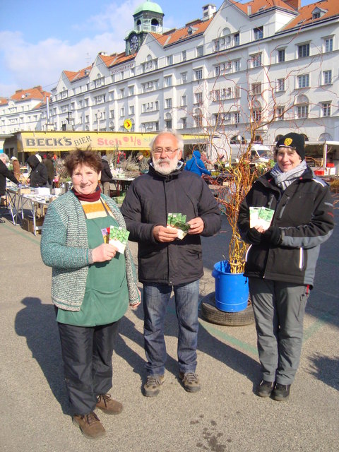 Günter Faulwetter übergibt Samenpäckchen mit Grünkohlgemüse an Anna und Elisabeth Hofer.