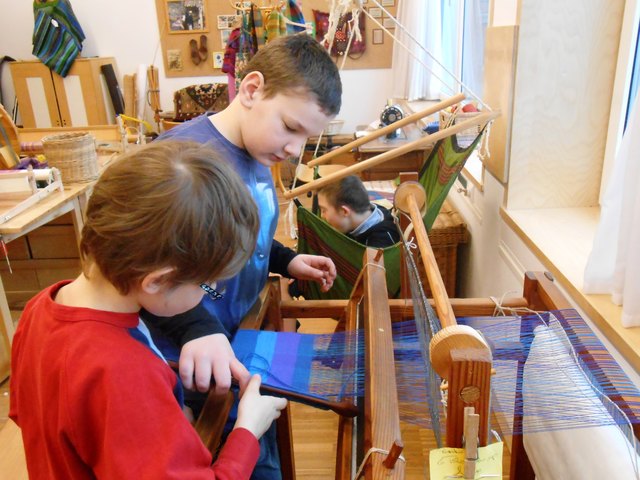 Die Kinder der Waldorfschule beim Arbeiten an alten Webstühlen (Schwerpunkt: Handwerks-Epoche).
