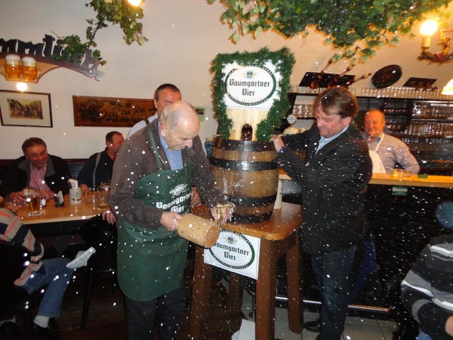 Karl Wageneder schlägt das Holzfass an, Braumeister Michael Moritz von der Brauerei Baumgartner assistiert.