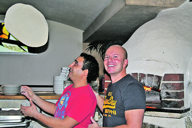 Schwungvoll geht's da zu: Pizzakoch Mikel aus Ägypten mit Paletti-Chef Wolfgang Grassl.