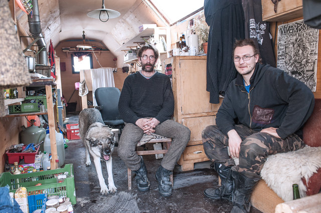 Wagenplatzbewohner  Martin Pell und Hans Freitag (v.l.) mit Hund Akita in Martins geräumigem Wagen.