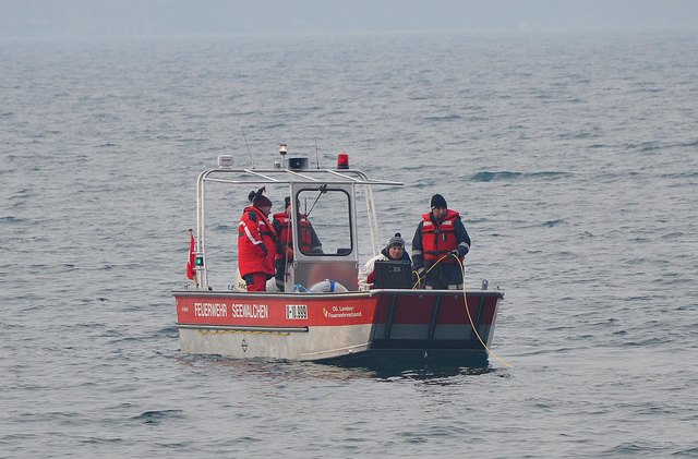 Feuerwehr Taucher suchen mittels Sonar-Gerät nach dem vermissten Taucher.