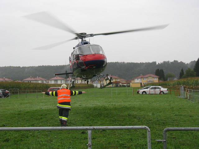 Feuerwehrflughelfer weist Hubschrauber ein.