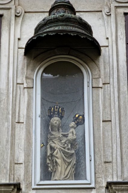 Wir bewundern diese hölzerne Madonnenstatue aus dem 15. Jhdt. an einem Barockhaus aus dem 18. Jhdt. (Schulhof)