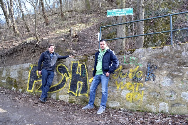 Mario Simoncsics und Markus Haderer von der Arbeitsgruppe Schlossberg vor einer besprühten Mauer am Schlossberg.