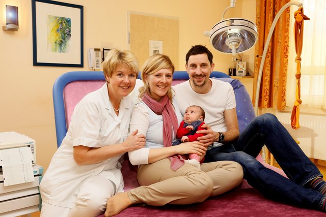 LKH Steyr: Die leitende Hebamme Doris Brillinger mit der jungen Familie Nina und Markus Etlinger und Baby Emma am breiten Entbindungsbett, für die familienfreundliche Geburt.