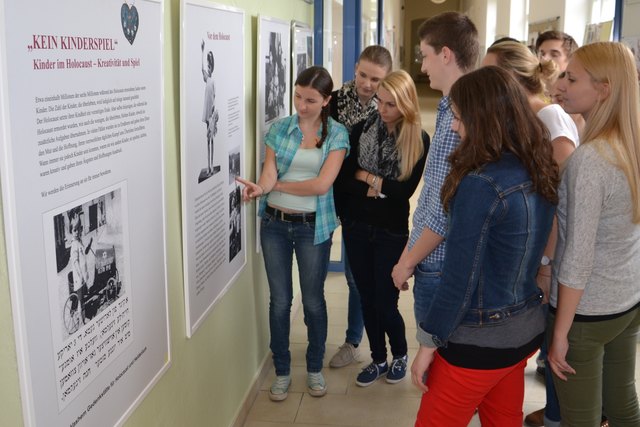 Schülerinen und Schüler betrachten interessiert die Ausstellung “No child´s play” über jüdische Kinder, die den Holocaust überlebt haben, in der HAK 1 Wels