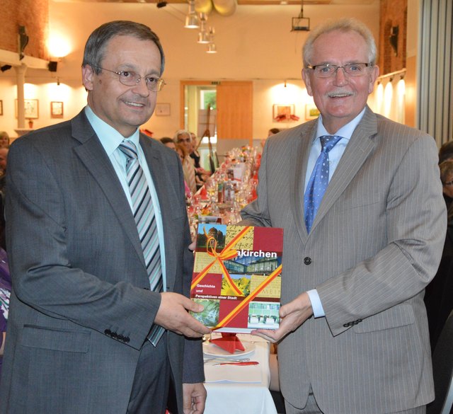 Bürgermeister OStR Mag. Anton Holzleithner überreichte Bürgermeister Bernd Roth das Laakirchner Heimatbuch und erhielt im Gegenzug eine von Ursula Zepter geschaffene Collage.