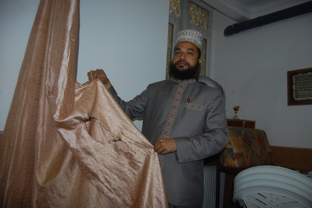 Muhammad Abdul Quaiyum zeigt einen der Vorhänge, der in Brand gesetzt wurde.
