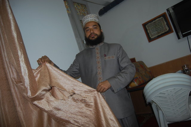 Muhammad Abdul Quaiyum zeigt einen der Vorhänge, der in Brand gesetzt wurde.