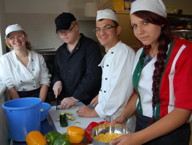 Cornelia, Martin, Armir und Katharina arbeiten in der Küche.