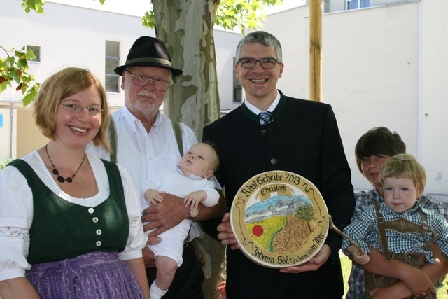 Der sichtlich stolze Großvater Johann Höll mit seinem fünften Enkel Christoph und der Ahnl-Scheibe.